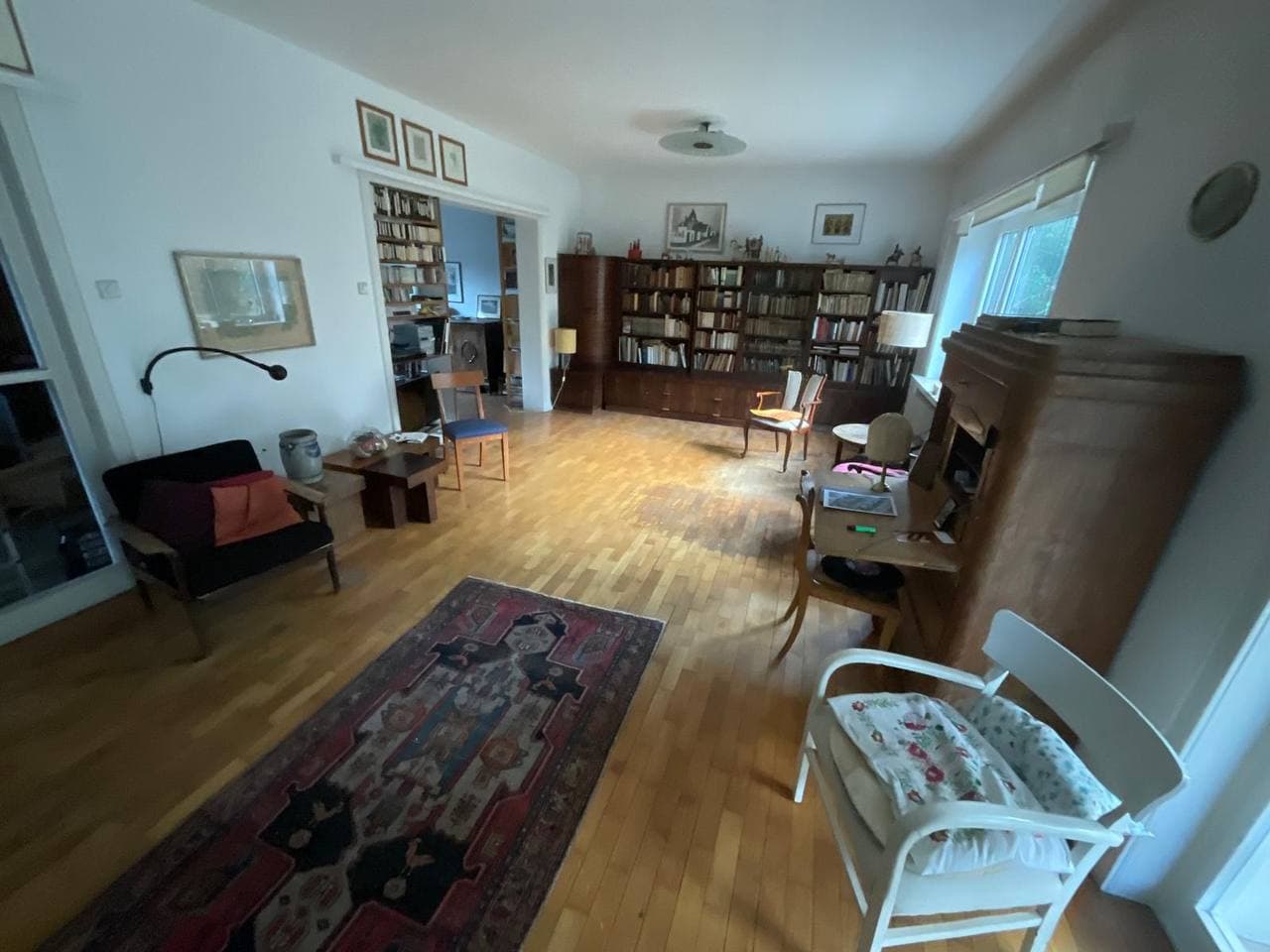 Eingerichtetes Wohnzimmer mit Bücherregal und Sessel vor der Haushaltsauflösung