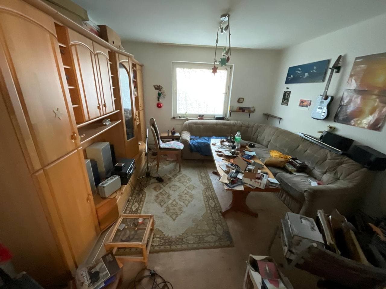 Voll eingerichtetes Wohnzimmer mit Schrankwand und Sofa vor der Räumung