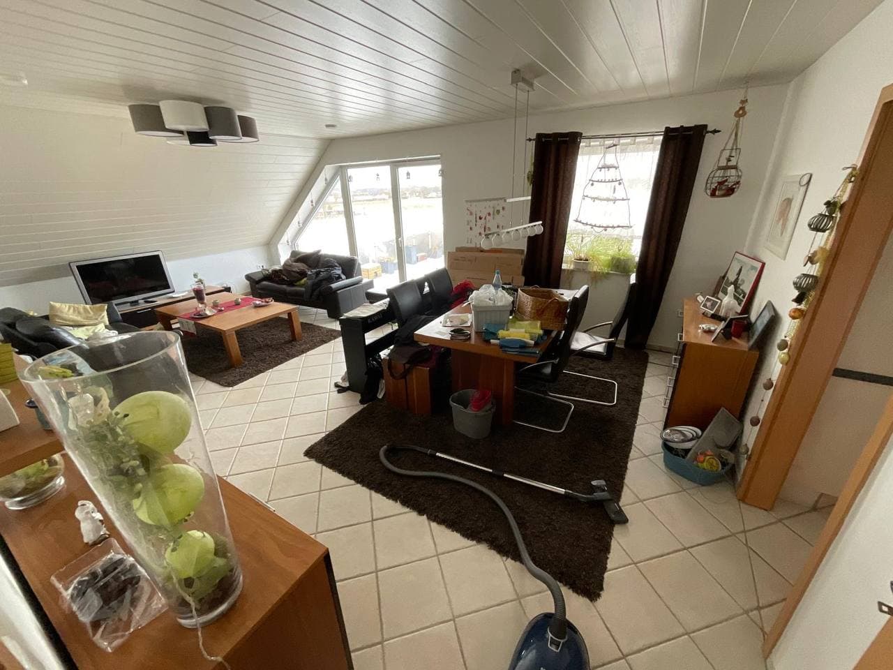 Eingerichtetes Wohnzimmer mit Sofa, Tisch und Teppich vor der Räumung